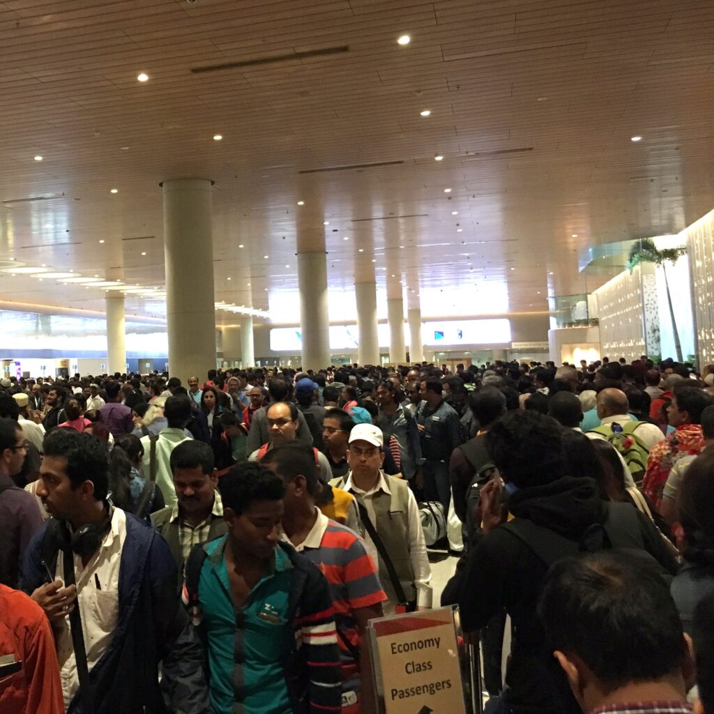 Travelers wait in line for passport control at Mumbai airport